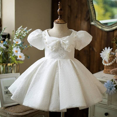 Robe baptême bébé fille blanche en dentelle avec nœud en satin et manches bouffantes