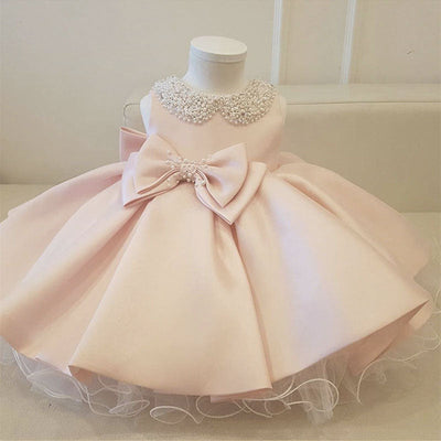 Robe baptême bébé fille rose pâle avec col orné de perles et nœud décoratif