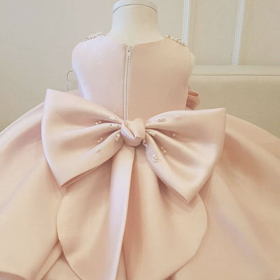 Robe baptême bébé fille rose pâle avec col orné de perles et nœud décoratif