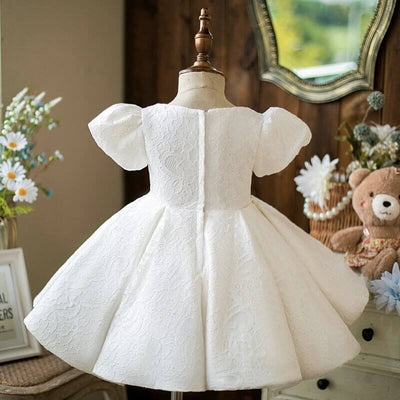 Robe baptême bébé fille blanche en dentelle avec nœud en satin et manches bouffantes